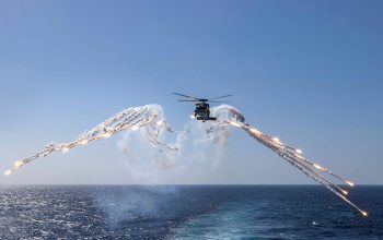 defence helicopter flying over water